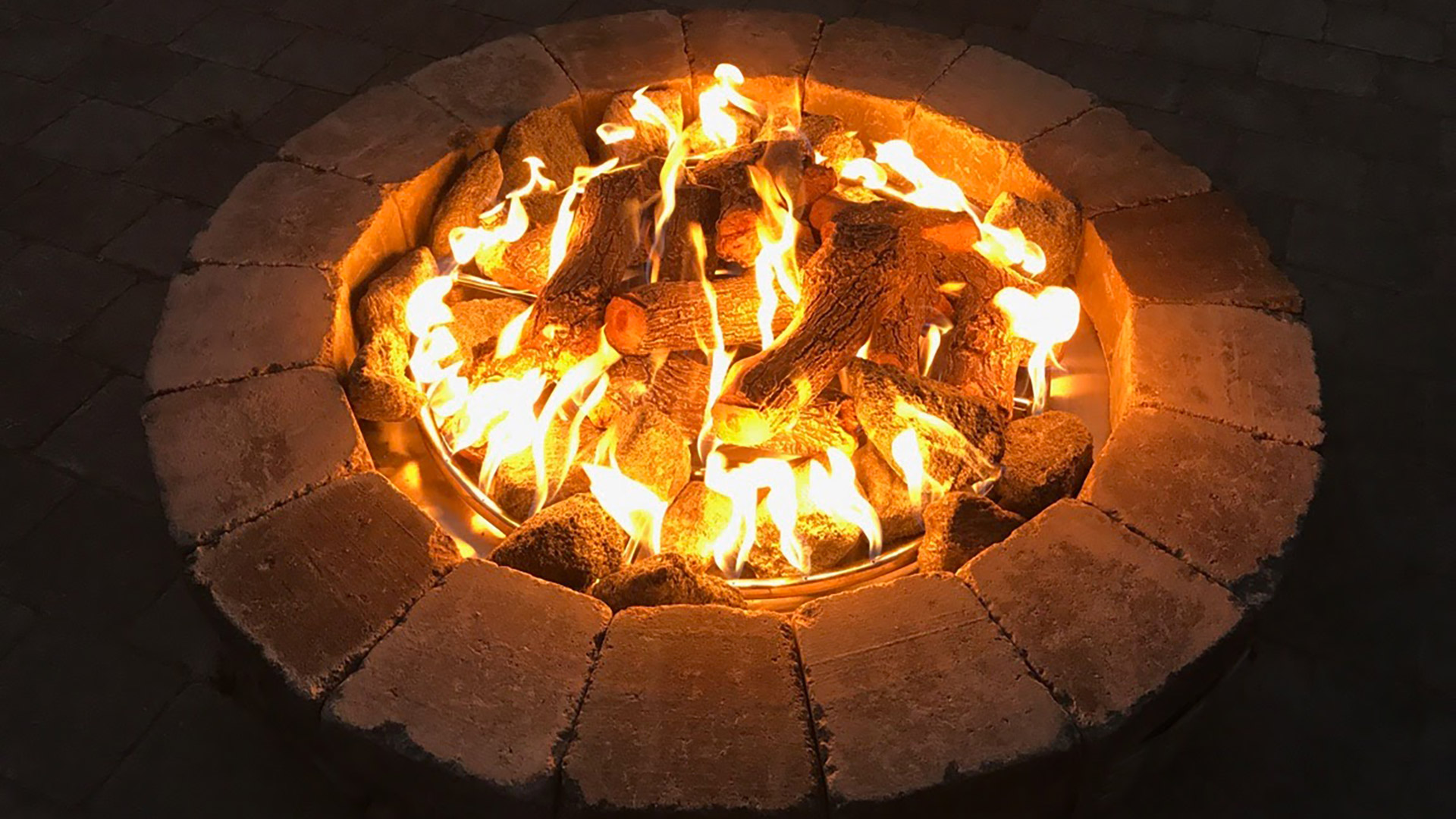 Flames in a custom built fire pit by a home in Haslett, MI.
