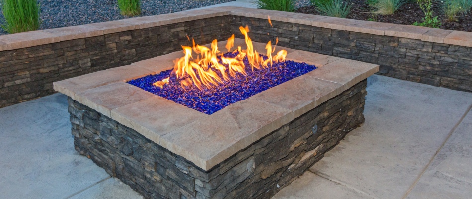 Gas burning fire pit installed with seating wall in Haslett, MI.
