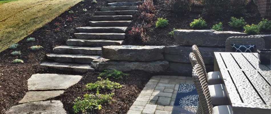 Custom stone steps installed around landscaping in Haslett, MI.